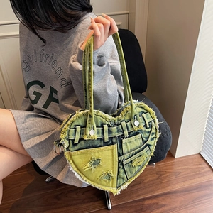 Heart-shaped denim handbag with distressed fraying and vintage utility style details