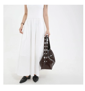Detail of dark brown leather crescent bag featuring large silver stud accents on shoulder strap