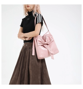 Detailed shot of pink patent leather tote bag with large studded bow decoration