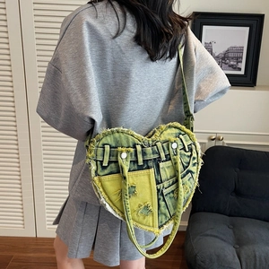 Heart-shaped washed denim crossbody bag with pockets and distressed frayed edge details