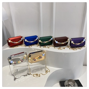 Detail of octagonal gemstone clutches with metallic chains and beaded handles in seven colors