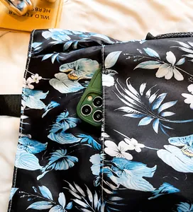 Close-up of durable side pocket on a floral Oxford cloth bag holding a smartphone