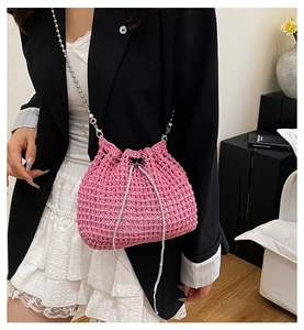 Détail du sac seau rose vif crocheté à la main avec fermoir papillon noir et cordon