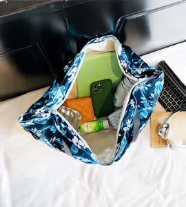 Top view of spacious floral tote bag interior holding a tablet, wallet, and essentials