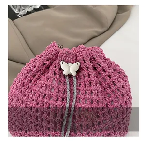Détail du sac seau au crochet dégradé rose avec fermoir papillon argenté et cordon de serrage