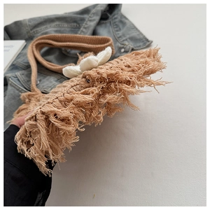 Detail of bohemian handmade woven tote bag with 3D floral accent and long fringe tassels
