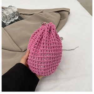 Détail du sac seau en tricot ajouré rose avec chaîne à billes argentée et cordon de serrage