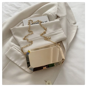 Close-up of golden octagonal faceted clutch bag with matching thick metal chain