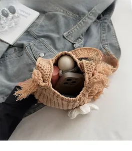 Beige hand-knitted square bag with tassel details showing large inner storage capacity