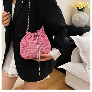 Détail du sac seau en maille rose avec fermoir papillon et bandoulière en perles