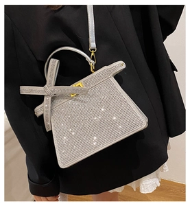 Vue latérale du sac à main argenté en strass sur un mannequin en blazer noir