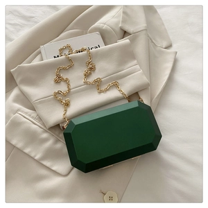 Close-up of geometric dark green acrylic box bag with gold chain and frosted texture