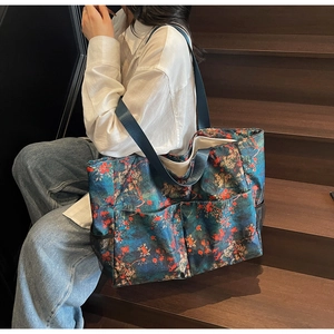 Detalle del bolso tote floral grande con bolsillos frontales y compartimentos laterales