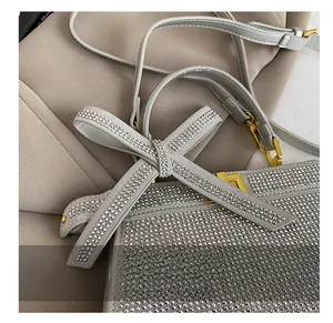 Gros plan du sac à main gris luxe avec strass argentés et détail noeud cristal