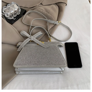 Détail du sac à main en strass argentés avec nœud en cristal et bandoulière en cuir