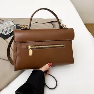 Detailed back view of caramel brown leather handbag featuring a secure gold zipper pocket