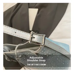 Dettaglio della tracolla con fibbia argentata su borsa in denim azzurro con strass