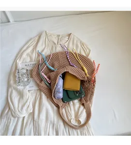 Detail view of large crochet shoulder bag with colorful drawstrings and interior storage