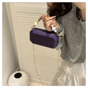Detail of purple geometric acrylic box bag with gradient bead handle and gold chain