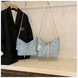 Vista dettagliata delle borse a spalla in denim azzurro con strass luccicanti e ciondoli M