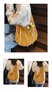 Close-up of yellow crochet hobo bag with colorful tassels and hollow mesh texture