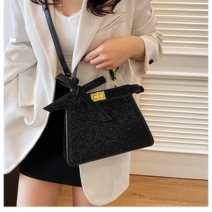 Détail du sac à main en strass noir avec fermoir doré et bandoulière en cuir