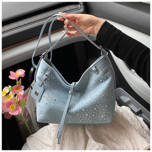 Dettaglio di borsa in denim celeste con strass scintillanti e tracolla regolabile
