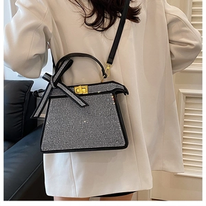 Détails du sac à main en strass avec boucle dorée et poignée ornée d'un nœud