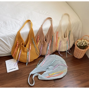 Detail of four colorful woven mesh tote bags with tassels in summer casual style