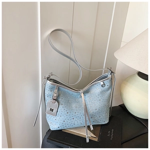 Dettaglio della borsa a spalla in denim azzurro con fitti strass argentati luccicanti