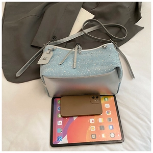 Dettaglio borsa a secchiello in denim con strass e base in ecopelle sintetica argento