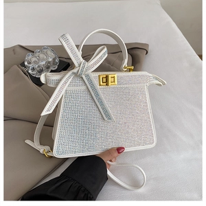 Détails de strass scintillants et fermoir doré sur un sac à main blanc élégant