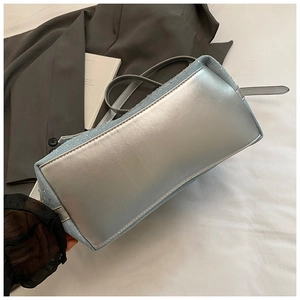 Vista dettagliata della borsa denim con base metallica argentata e strass luminosi