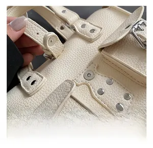 Close-up of litchi texture leather handbag with silver buckles and stud details