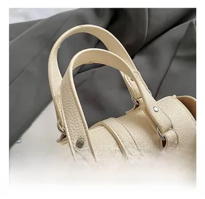 Close-up of cream lychee texture leather handbag with silver rivets and metal hardware