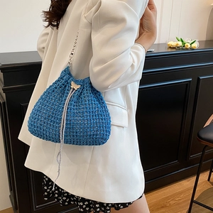 Sac seau en tricot bleu avec chaîne métallique et breloque papillon sur mannequin