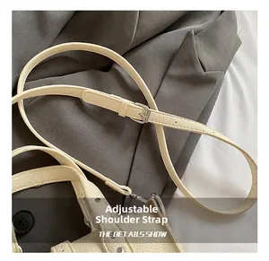 Macro shot of adjustable cream lychee leather shoulder strap with silver buckle detail