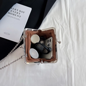 Vertical metal frame chain bag with retro clasp showing interior capacity and storage space
