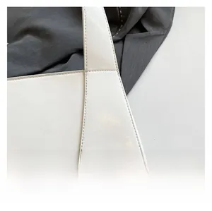 Detailed close-up of premium white leather texture and precise stitching on lady handbag