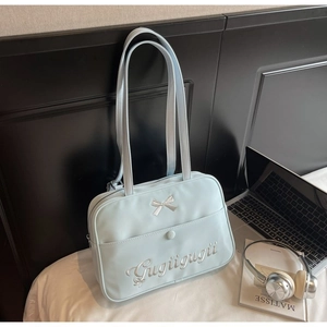 Detail of light blue tote bag with silver bow and Gugiigugii embroidery for students