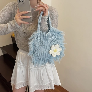 Handmade knitted light blue handbag featuring floral decoration and fringe details