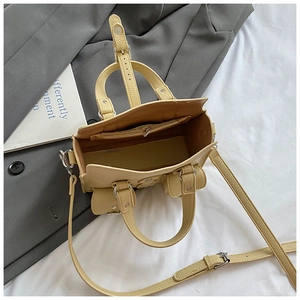 Detailed interior view of beige pebble leather handbag with silver zip pocket and shoulder strap