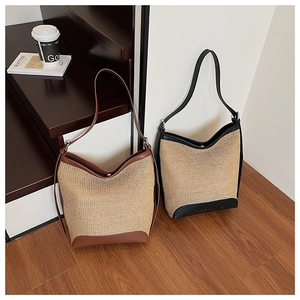 Detailed view of straw woven tote bags with leather trim in brown and black options