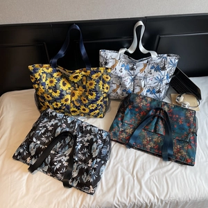 Spacious printed beach tote bags with sunflower and leopard patterns on a white bed