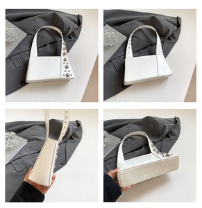 Detail view of white punk style handbag with metallic rivets and geometric structure