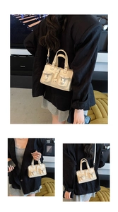 Detail of cream multi-pocket crossbody bag with metallic buckles and sturdy handle