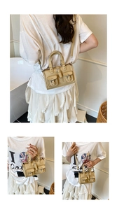 Detail view of beige multi-pocket biker handbag with silver buckles and adjustable strap