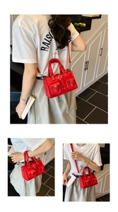 Detailed view of red leather moto-style handbag with utility pockets and silver hardware