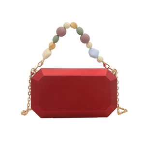 Red geometric acrylic box bag with colorful beaded handle and gold chain strap