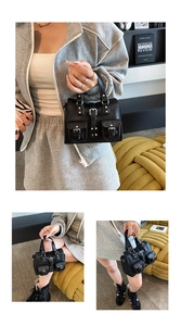 Detail of black lychee grain leather mini tote with silver buckles and decorative pockets